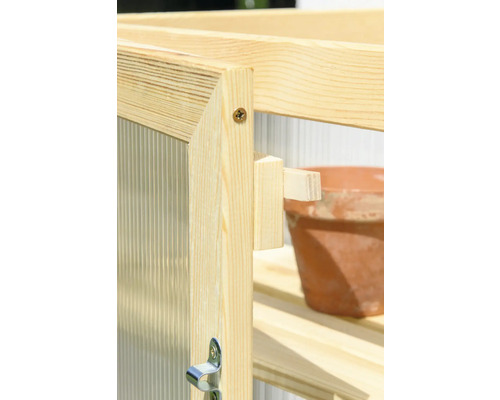 Detailansicht eines Gewächshauses aus Holz mit Regalen und einem Blumentopf