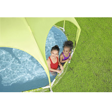 Zwei Kinder spielen in einem Planschbecken mit Sonnenschutz auf einer Wiese.