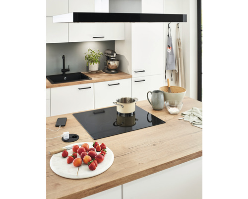 Cuisine moderne avec plaque à induction, évier, robinet et fruits frais sur le plan de travail