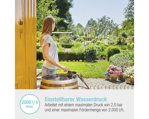 Frau bedient Gartenpumpe im Garten zur Bewässerung