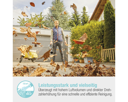Mann bläst Laub mit einem Laubbläser vor einer Garage