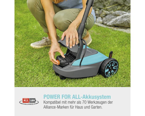 Frau setzt Akku in einen Rasenmäher