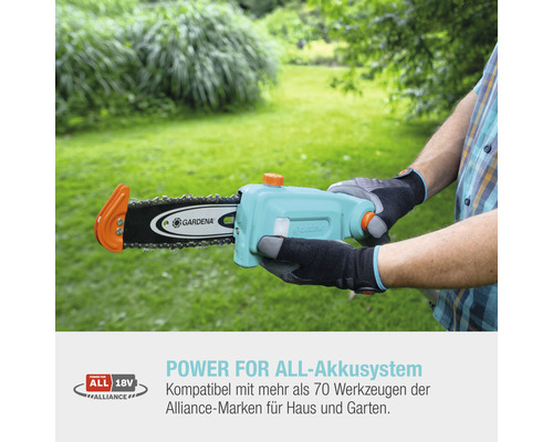 Eine Person hält eine Gardena Akku-Kettensäge im Garten.
