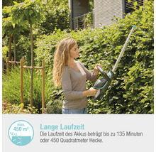 Frau schneidet Hecke mit Akku-Heckenschere im Garten