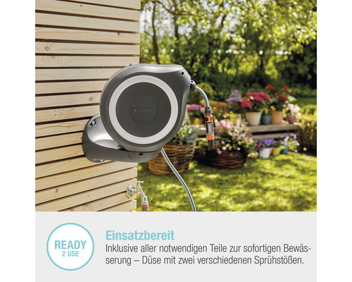 Auf einer Holzwand montierte Gardena Schlauchbox mit Gartenschlauch im Garten