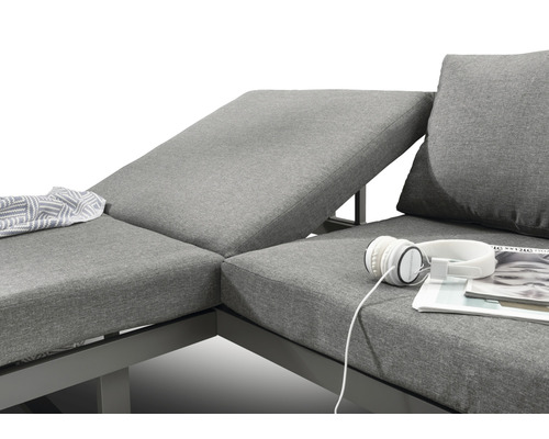 Gros plan d''un salon de jardin gris avec coussins, couverture, casque et magazine