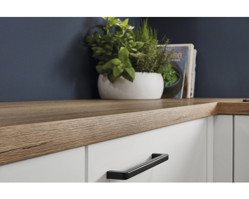Küchenarbeitsplatte in Holzoptik auf weißen Schränken mit schwarzem Griff