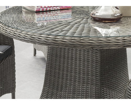 Vue détaillée d''une table de jardin avec plateau en verre et structure en rotin