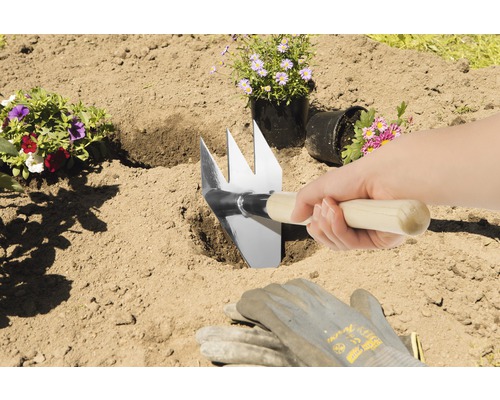 Gartenhacke im Einsatz beim Einpflanzen von Blumen
