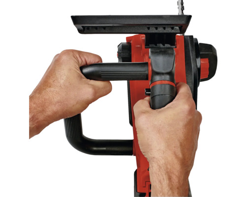 Une personne tient une tronçonneuse à deux mains.