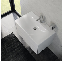 Salle de bains moderne avec lavabo blanc, robinetterie et espace de rangement