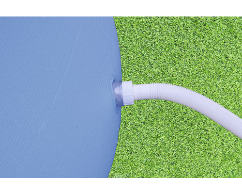 Détail d''une piscine avec un tuyau raccordé sur une pelouse