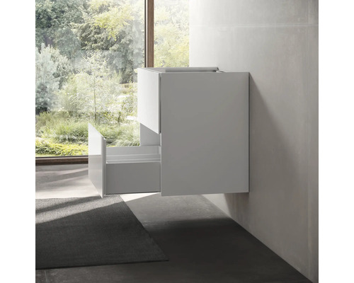 Meuble sous-lavabo avec tiroir ouvert devant la fenêtre