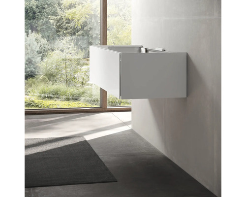 Salle de bains moderne avec meuble sous-lavabo et fenêtre donnant sur la verdure.