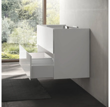 Meuble sous-lavabo suspendu avec tiroirs ouverts devant une fenêtre