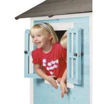 Fille regardant par la fenêtre d''une cabane en bois pour enfants