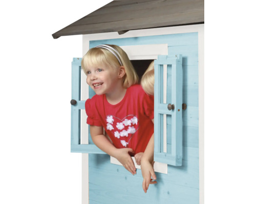 Fille regardant par la fenêtre d''une cabane en bois pour enfants