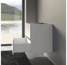 Meuble sous-lavabo blanc avec tiroir ouvert sur un mur de salle de bain