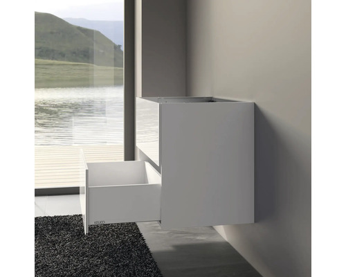 Meuble sous-lavabo blanc avec tiroir ouvert sur un mur de salle de bain