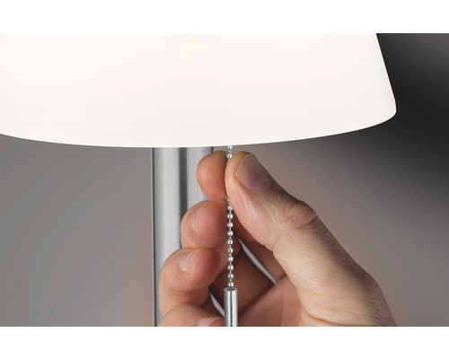 Eine Hand zieht an einer Kette, um eine Lampe einzuschalten