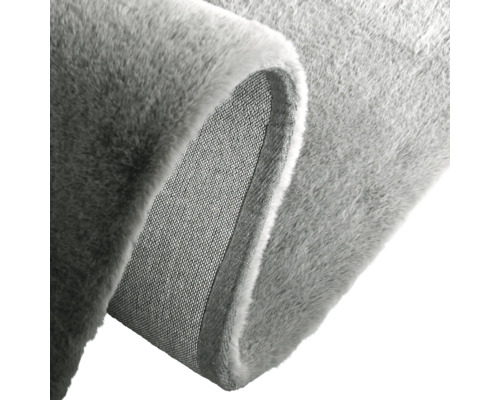 Detailansicht eines grauen Teppichs mit gewebter Rückseite