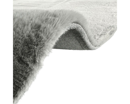 Vue détaillée d''un tapis gris avec une surface en velours et un dos en textile