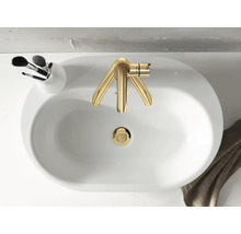 Vue de dessus d''un lavabo avec robinetterie dorée, un support avec des pinceaux de maquillage et une serviette