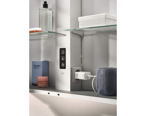 Badezimmerszene mit Spiegelschrank inklusive Steckdose und Kosmetikprodukten