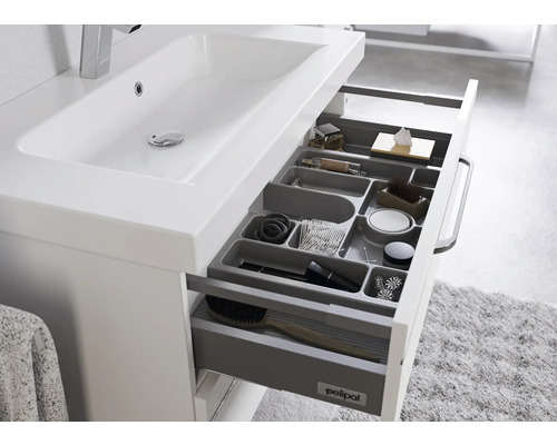 Meuble sous-lavabo avec tiroirs ouverts et système de rangement.