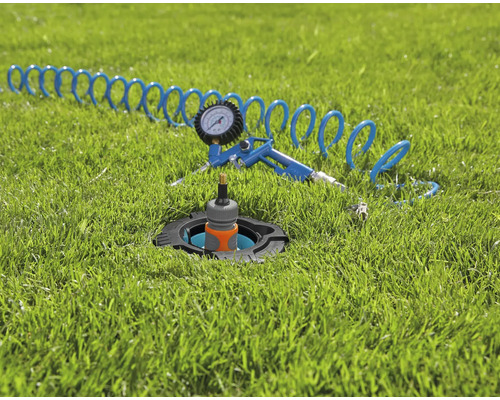 Versenkregner mit Druckluftpistole und Schlauch auf Rasen