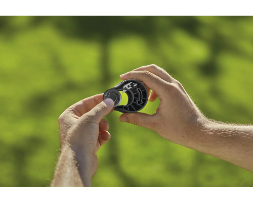 Person hält Bindewerkzeug für Pflanzen