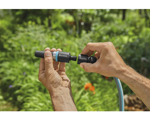 Hände verbinden Gardena Schlauchverbinder mit Gartenschlauch