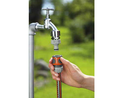 Gartenschlauchanschluss an Wasserhahn im Garten.