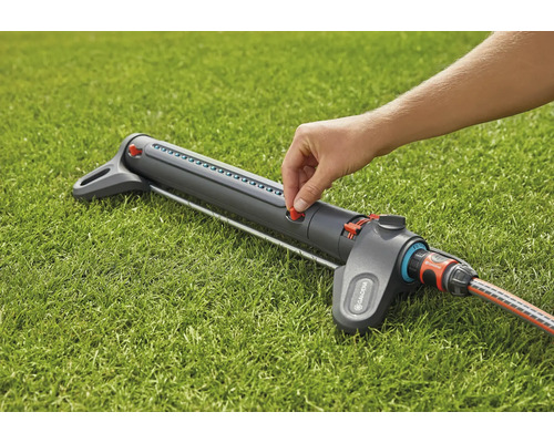 Gardena Regner auf Rasen mit Hand an rotem Regler