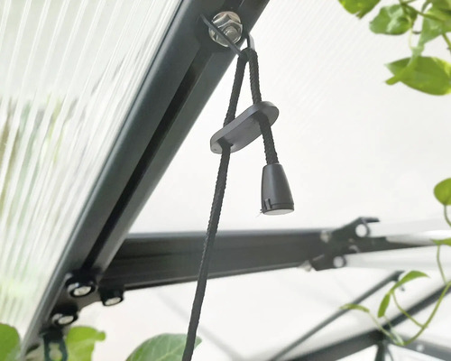 Detailaufnahme eines Fensteröffners mit Kordelzug in einem Gewächshaus.