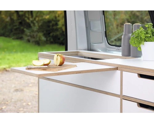 Aménagement de camping avec table coulissante, planche à découper, couteau et pomme