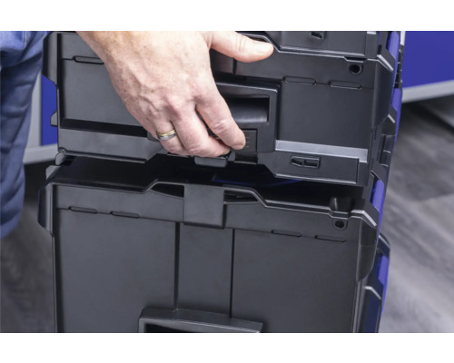 Une personne ouvre une boîte à outils en plastique.