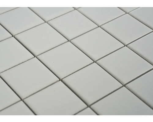 Gros plan de carreaux carrés disposés en diagonale, formant un motif répétitif.