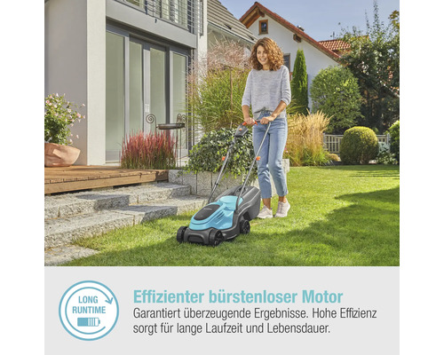 Frau benutzt einen Rasenmäher im Garten.