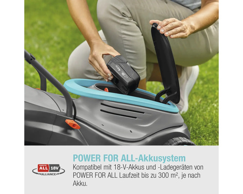 Eine Person setzt einen Akku in einen Rasenmäher ein.