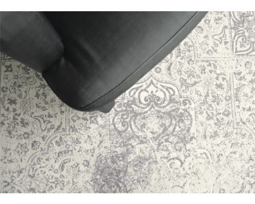 Gros plan d''un tapis à motifs floraux et d''une partie d''un fauteuil