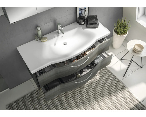 Badezimmer Waschbeckenunterschrank mit offen Schubladen und weißem Aufsatzwaschbecken in einem hellen Badezimmer.