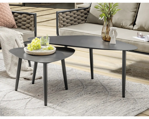 Deux tables basses triangulaires grises sur un tapis d''extérieur gris.