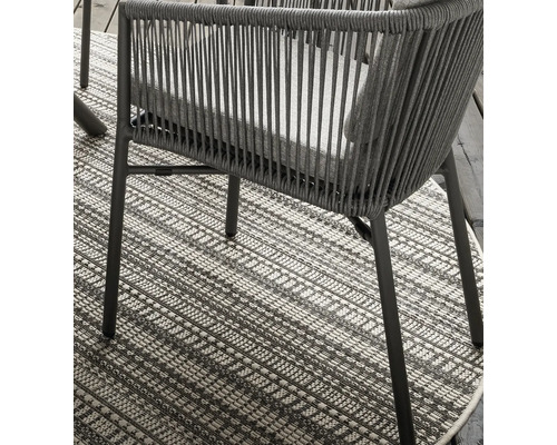 Detailansicht eines Stuhls auf einem gemusterten Teppich