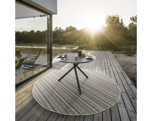 Table de jardin ronde avec petit-déjeuner sur une terrasse en bois