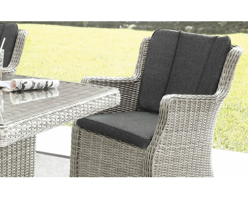 Gros plan d''une chaise de jardin tressée avec accoudoirs et coussins gris, faisant partie d''un ensemble de sièges