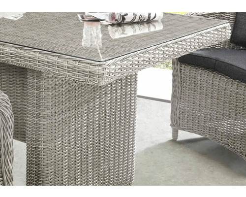 Détail d''une table de jardin avec plateau en verre et tressage en rotin