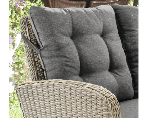 Detailansicht eines Rattansessels mit grauem Sitzkissen und Rückenlehne