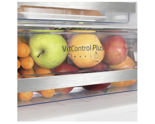 Nahaufnahme des Gemüsefachs eines Kühlschranks gefüllt mit Äpfeln und Karotten