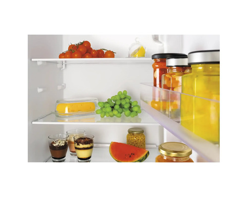 Innenansicht eines Kühlschranks mit Lebensmitteln wie Tomaten, Trauben, Wassermelone und Gläsern mit Desserts